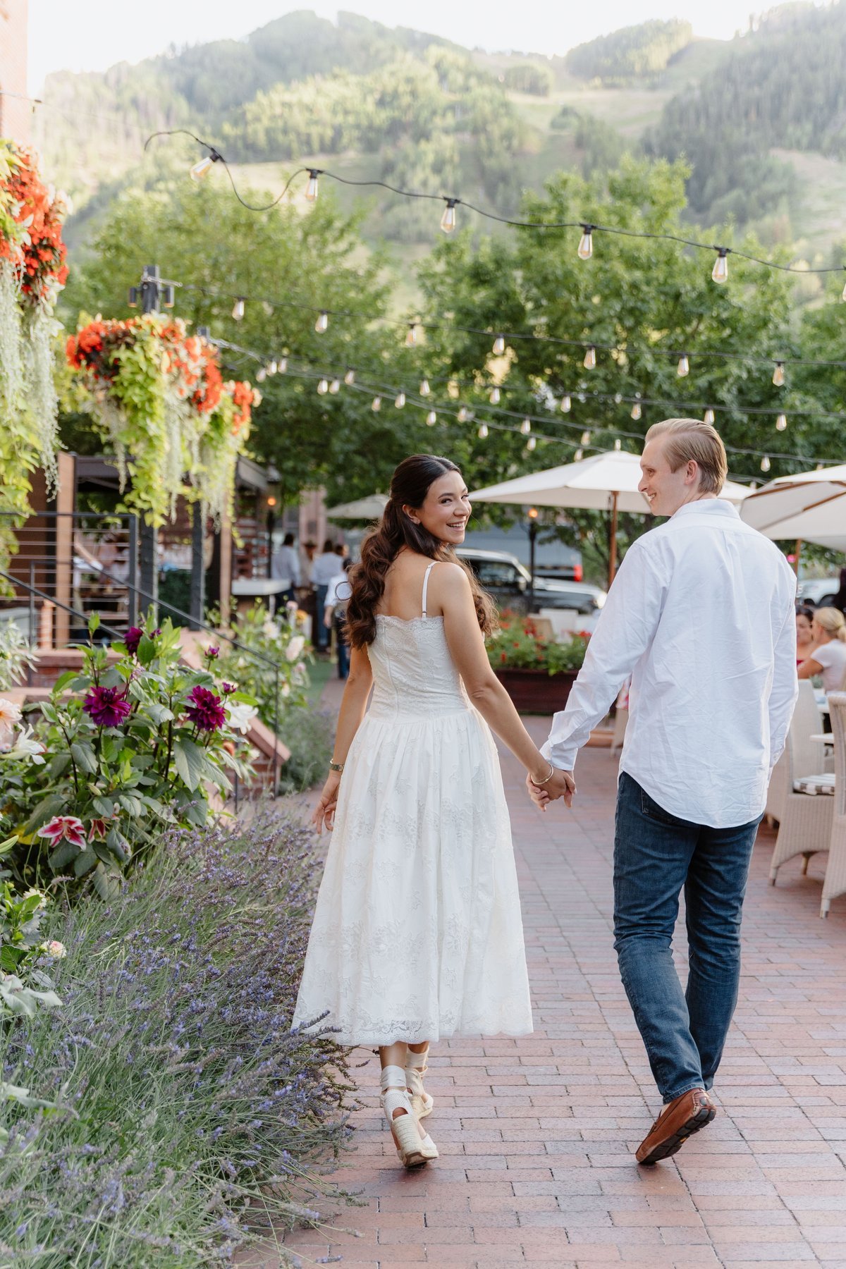 Valeria and Zachary walking hand in hand through Aspen